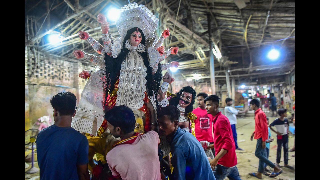 Devotees carry a clay idol of Hindu goddess Durga at a workshop during the ongoing Navratri festival in Allahabad. Pic/AFP